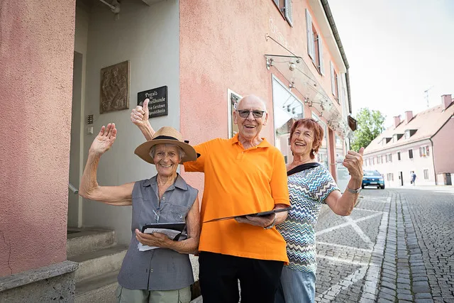 Drei jubelnde ältere Menschen auf einer Straße