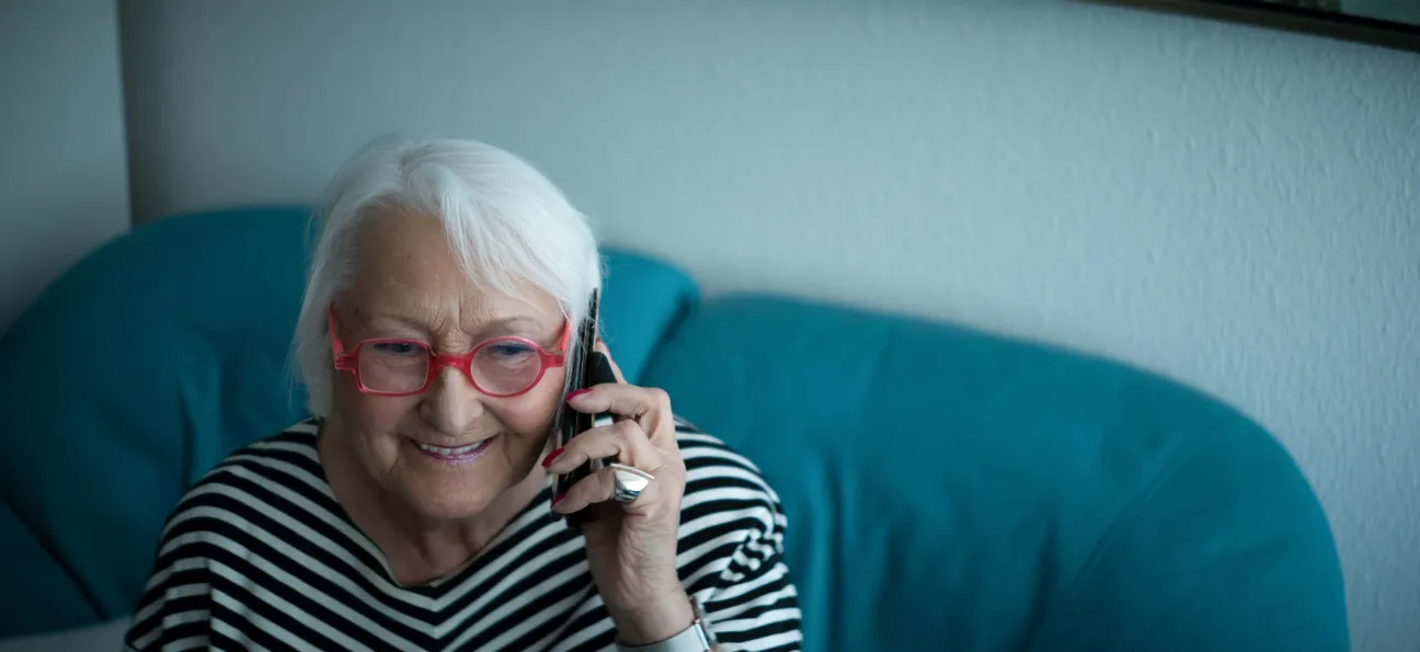 Ältere Frau telefoniert lächelnd.