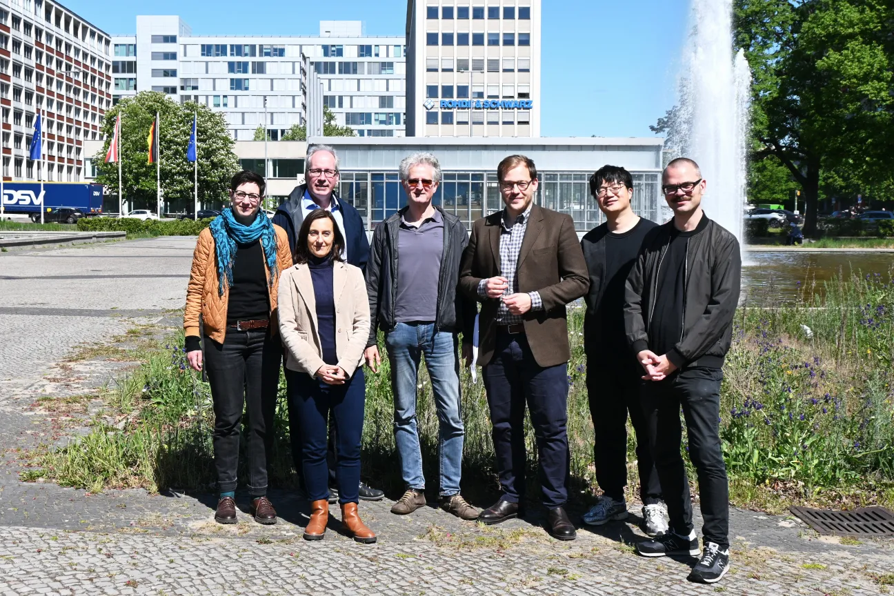 Menschen stehen in einer Stadt vor einer Wiese in der Gruppe. Es ist das Team von Pflege 4.0