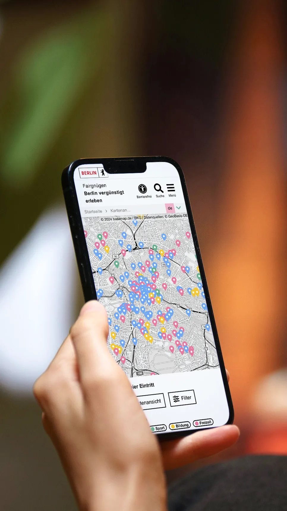 Hand hält ein Smartphone. Die Karte von Fairgnügen ist darauf zu sehen..